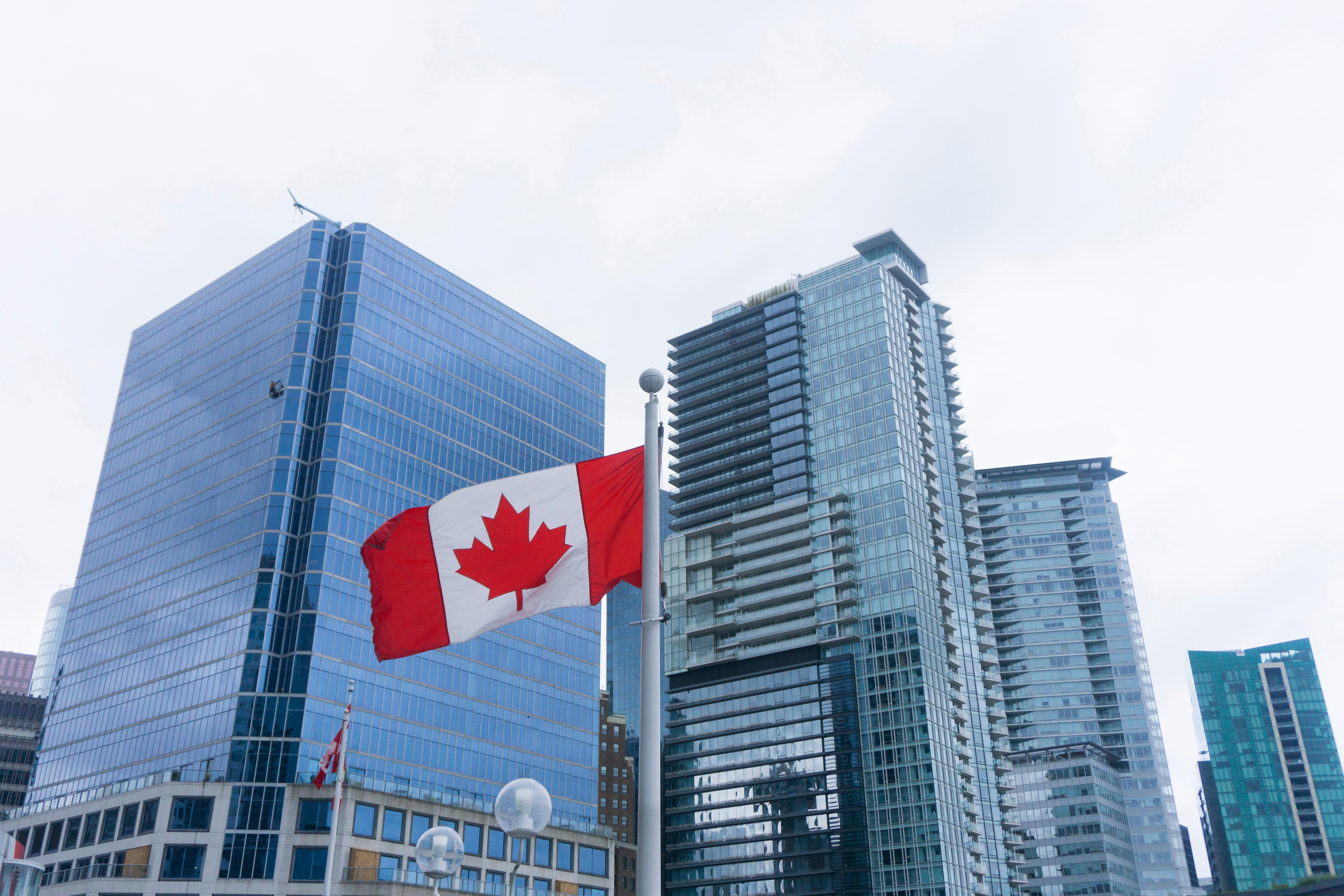The Canadian flag against the backdrop of offices symbolizes Canadian citizenship by investment