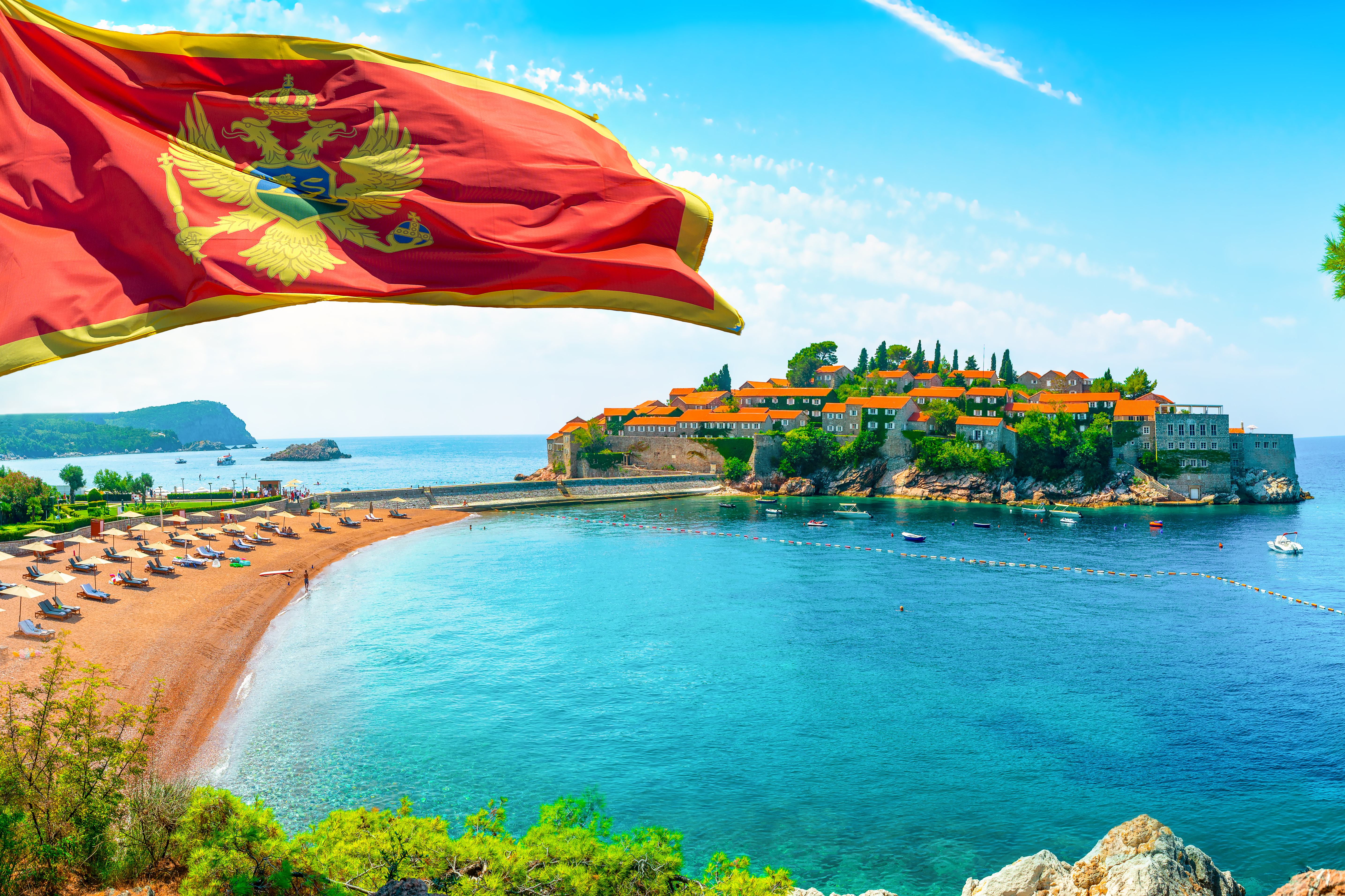 Flag against the background of the Montenegrin coast, the place where you want to move and live in Montenegro