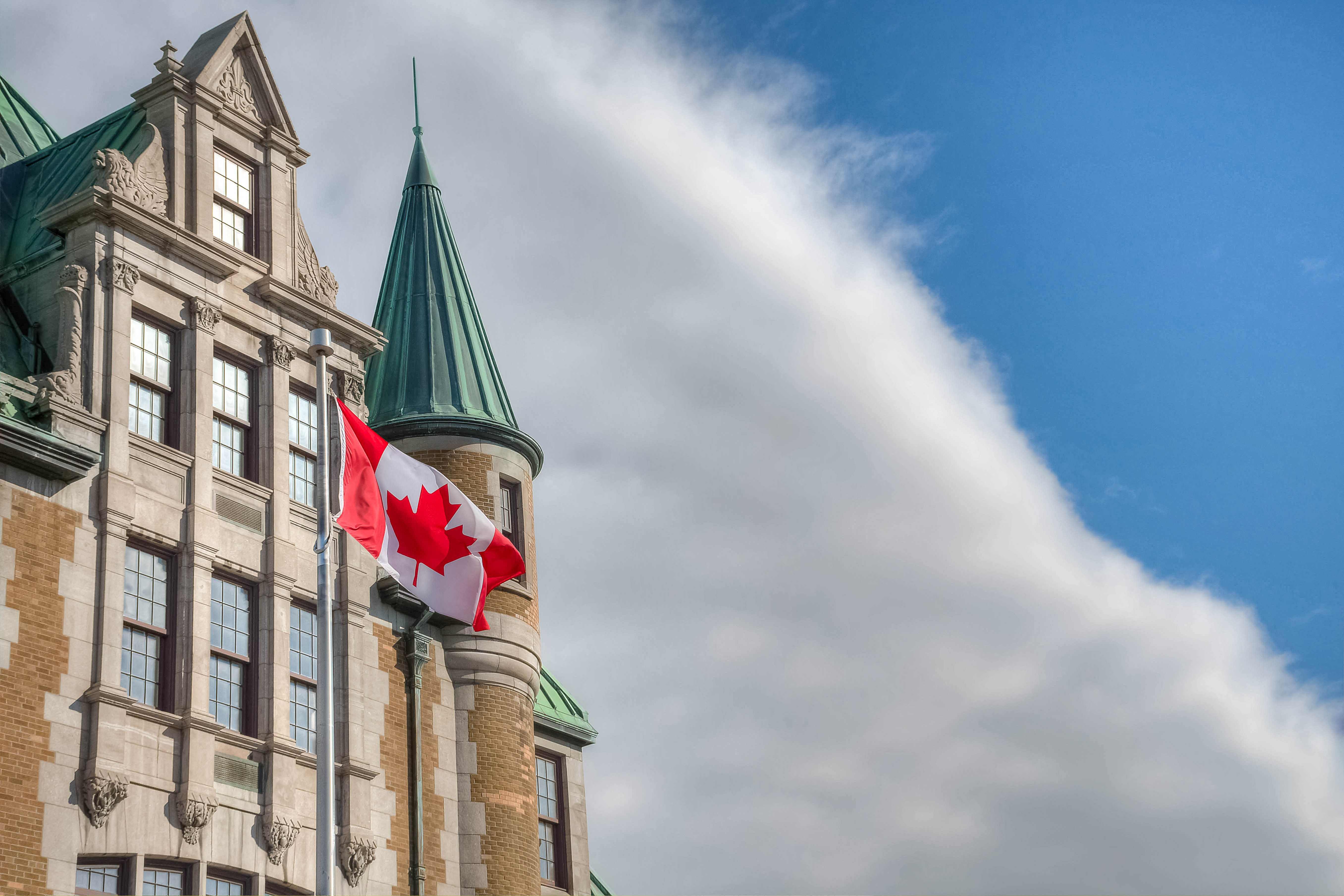 Building with the Canadian flag, as a symbol of immigration to Canada under the provincial program