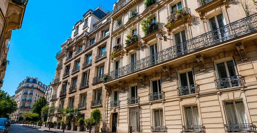 Traditional stone apartment buildings with wrought-iron balconies, illustrating residential rental housing in France